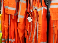 26 werkoveralls en werkbroeken met borststuk op twee rekken. - afbeelding 2 van  3