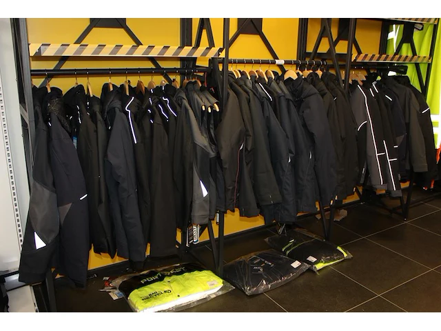 40 werkjassen en bodywarmers op rek in diverse maten merken en uitvoeringen aan en onder drie rekken. - afbeelding 2 van  2