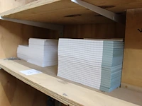 85 schrijfblokjes met ruiten op schap. - afbeelding 1 van  2