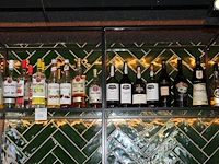 Aangebroken flessen sterke dranken op vijf schappen. - afbeelding 3 van  5