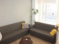 Bankstel bestaande uit een grijs/bruin gestoffeerde twee- en driezitsbank met breedte 200 cm en 180 cm en e...
