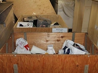 Beursmaterialen in twee houten kratten waaronder pannen, glaswerk, schoonmaakmiddelen enz. - afbeelding 1 van  3
