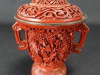 Chinese koperen gelakte vaas, waarschijnlijk van gesneden cinnober of een imitatie daarvan. cinnober is een helderrode tot scharlakenrode vorm van kwiksulfide, die van oudsher werd gebruikt als pigment.