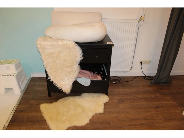 Commode met voedingskussen, twee kunstdierenvellen, plaids, kunstbloemen enz. let op! een lade ontbreekt. a... - afbeelding 1 van  2
