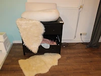 Commode met voedingskussen, twee kunstdierenvellen, plaids, kunstbloemen enz. let op! een lade ontbreekt. a... - afbeelding 1 van  2