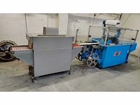 De knegt verpakkingsmachine met krimptunnel