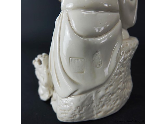 Dehua figurine bezig met dressuur fu dog zittend op een rots, blanc de chine 19/20e eeuw met blindmerk - afbeelding 4 van  5