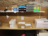 Diverse kantoormaterialen op twee schappen. - afbeelding 2 van  2