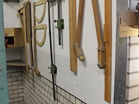 Diverse meetinstrumenten waaronder passer, linialen en blokhaken aan wand. - afbeelding 2 van  3