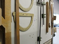 Diverse meetinstrumenten waaronder passer, linialen en blokhaken aan wand. - afbeelding 3 van  3