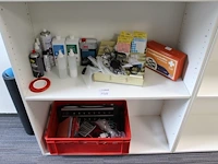 Diverse reinigingsmiddelen, kantoormaterialen en verbandtrommel op twee schappen - afbeelding 1 van  2