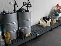 Drie olieopvangbakken met diverse opvoerpompen, schenkkannen en enkele restanten olie. - afbeelding 2 van  4