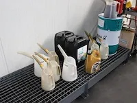 Drie olieopvangbakken met diverse opvoerpompen, schenkkannen en enkele restanten olie. - afbeelding 4 van  4