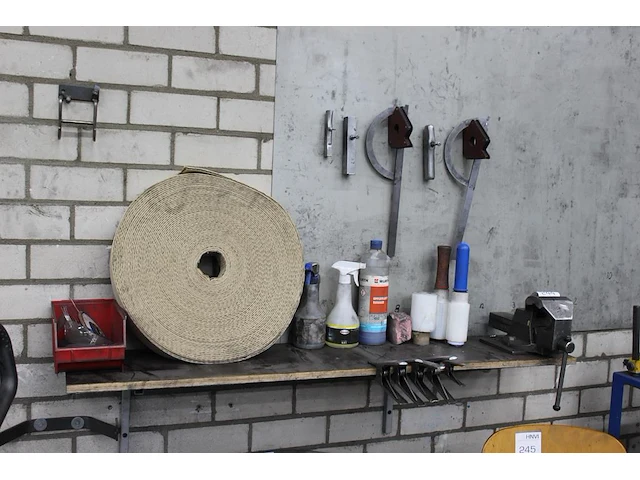 Gereedschappen op en boven plank w.o. bankschroef, magneethoeken, klemmen en handsealfolie. - afbeelding 1 van  2