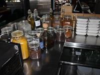 Glazen flessen en weckpotten gevuld met diverse specerijen en oliën. - afbeelding 2 van  2