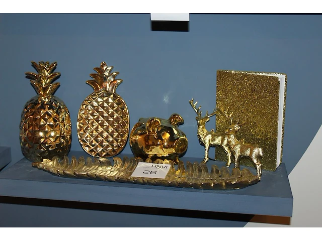 Goudkleurige decoratie op schap w.o. herten, varken, palmblad en ananas. - afbeelding 1 van  1