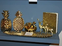 Goudkleurige decoratie op schap w.o. herten, varken, palmblad en ananas. - afbeelding 1 van  1