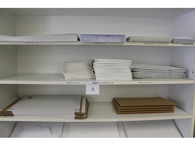 Grote diversiteit enveloppen en verzenddozen in schappenkast. - afbeelding 2 van  4