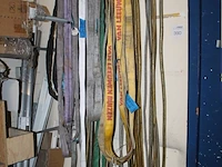 Grote hoeveelheid hijsbanden, staalkabels en ogen aan wand. - afbeelding 2 van  3