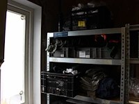 Grote hoeveelheid kleding en schoenen, waaronder blouses, t-shirts, sloven en bretels op vijf schappen en a... - afbeelding 1 van  3