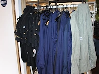 Grote hoeveelheid kleding en schoenen, waaronder blouses, t-shirts, sloven en bretels op vijf schappen en a... - afbeelding 2 van  3