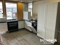 Hoekopgestelde showroomkeuken met inbouw apparatuur en granieten blad - afbeelding 18 van  22