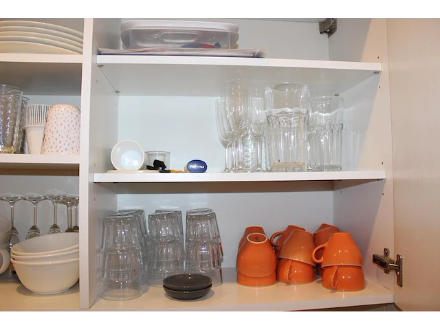 Inhoud keukenblok waaronder serviesgoed, glaswerk, bakjes, tosti-ijzer, waterkoker, poetsdoeken, waterkanne... - afbeelding 1 van  7