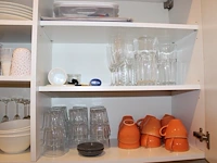 Inhoud keukenblok waaronder serviesgoed, glaswerk, bakjes, tosti-ijzer, waterkoker, poetsdoeken, waterkanne... - afbeelding 1 van  7