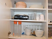 Inhoud keukenblok waaronder serviesgoed, glaswerk, bakjes, tosti-ijzer, waterkoker, poetsdoeken, waterkanne... - afbeelding 7 van  7