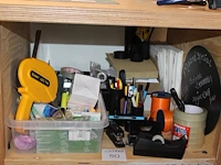 Kantoormaterialen op schap waaronder schrijfgerei, lint, tape en perforator. - afbeelding 1 van  2