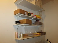Kantoorproducten waaronder displayhouders, brievenbakjes, potloden, tape, papier, enz. op vier schappen. - afbeelding 1 van  3