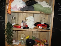 Kinderspeelgoed in en om schappenkast waaronder knuffels, petten en brillen. - afbeelding 2 van  3