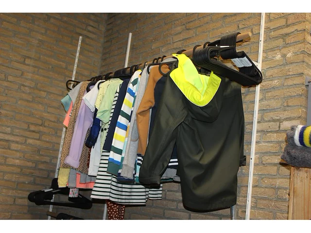 Kleding, tassen en schoenen in schappenkast en aan rek. - afbeelding 1 van  5