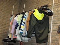 Kleding, tassen en schoenen in schappenkast en aan rek. - afbeelding 1 van  5