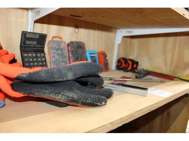 Klusproducten waaronder bitjes, handschoenen en rolmaten op schap. - afbeelding 2 van  2