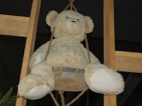 Knuffelbeer met lengte circa 80 cm op schommel. - afbeelding 1 van  2