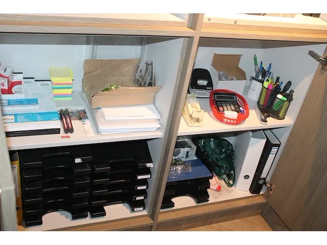 Koopje kantoormaterialen in twee kastdelen w.o. brievenbakjes, schrijfgerei, schrijfblokken en perforator. - afbeelding 1 van  1