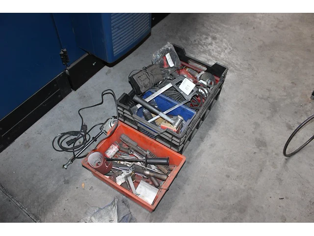 Machineonderdelen en gereedschappen in en om kist. - afbeelding 1 van  2