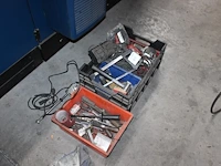 Machineonderdelen en gereedschappen in en om kist. - afbeelding 1 van  2