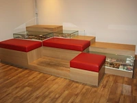 Podium met kussens en vitrines afm. 360 x 180 cm.