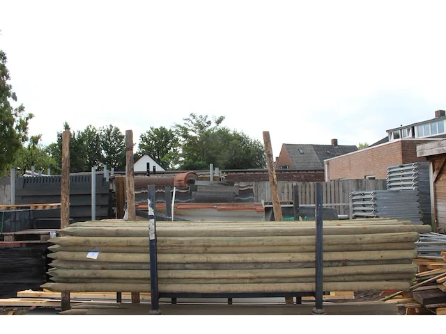 Ruim 70 boompalen in metalen bok. lengte 250 cm. doorsnede 55 mm. let op: exclusief bok. - afbeelding 1 van  3