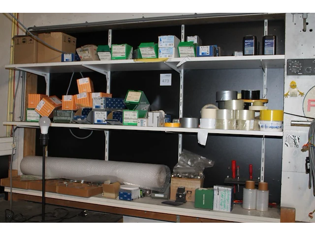 Schroeven, revetten, moeren, tape, krimpfolie, bubblefolie, blokbatterijen, enz. op drie schappen. - afbeelding 1 van  1