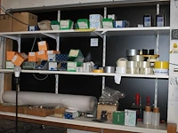Schroeven, revetten, moeren, tape, krimpfolie, bubblefolie, blokbatterijen, enz. op drie schappen. - afbeelding 1 van  1