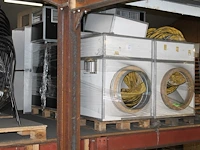Tentverwarmingsonderdelen op en naast vier pallets, waaronder kasten en aan-/afvoerslangen. - afbeelding 1 van  3