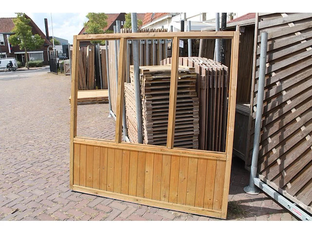 Twee houten terrasafscheidingen met schaamschot en 3 kozijnen per deel. let op: glas ontbreekt - afbeelding 1 van  2