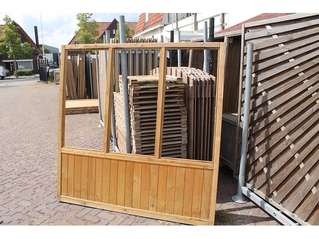 Twee houten terrasafscheidingen met schaamschot en 3 kozijnen per deel. let op: glas ontbreekt - afbeelding 1 van  2
