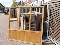 Twee houten terrasafscheidingen met schaamschot en 3 kozijnen per deel. let op: glas ontbreekt - afbeelding 1 van  2