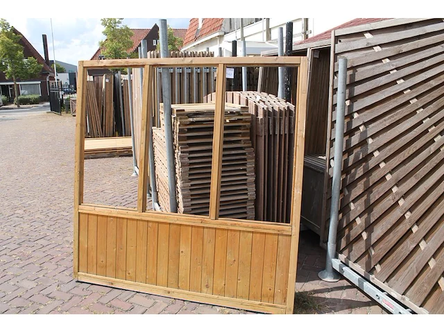 Twee houten terrasafscheidingen met schaamschot en 3 kozijnen per deel. let op: glas ontbreekt - afbeelding 1 van  2
