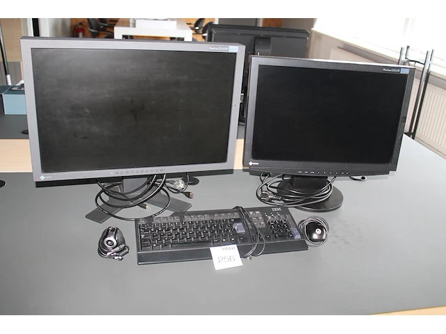 Twee monitoren eizo flexscan s240w 24 inch en s2111w 21 inch met toetsenbord, camera en muis. - afbeelding 1 van  3