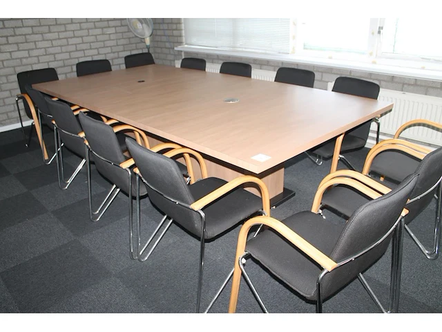 Vergadertafel met 14 zwart gestoffeerde buisstalen stoelen met houten armleuningen, waarvan enkele beschadi... - afbeelding 1 van  3